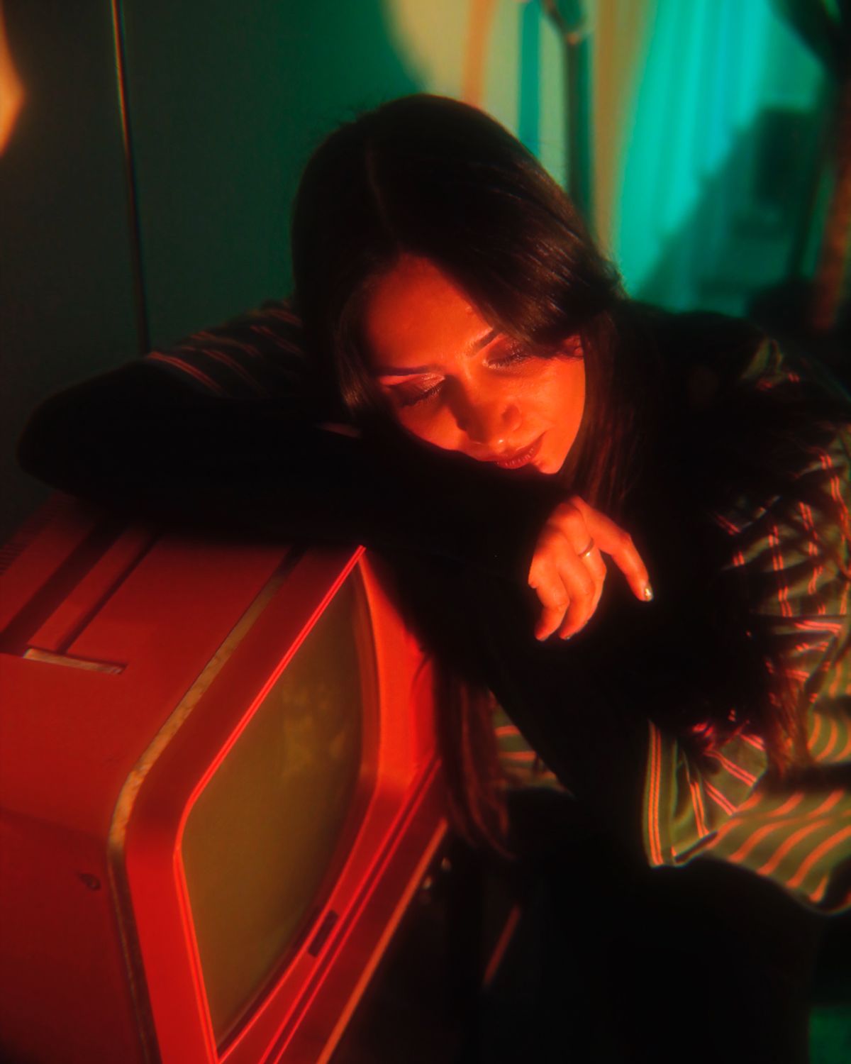 Escena dramática con luz roja junto a un televisor retro